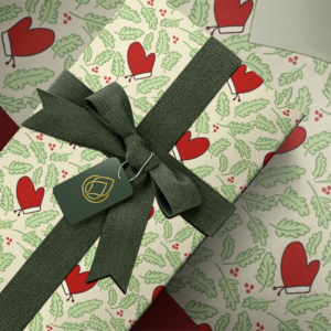 Christmas gift wrap mockup featuring a festive winter pattern with red mittens, green leaves, and holiday berries