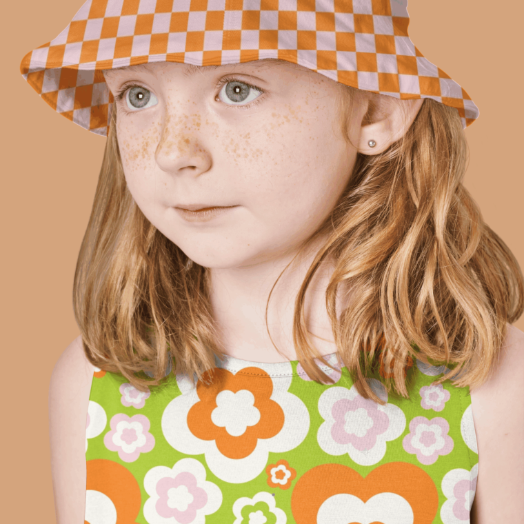 Child wearing orange floral pattern outfit and hat
